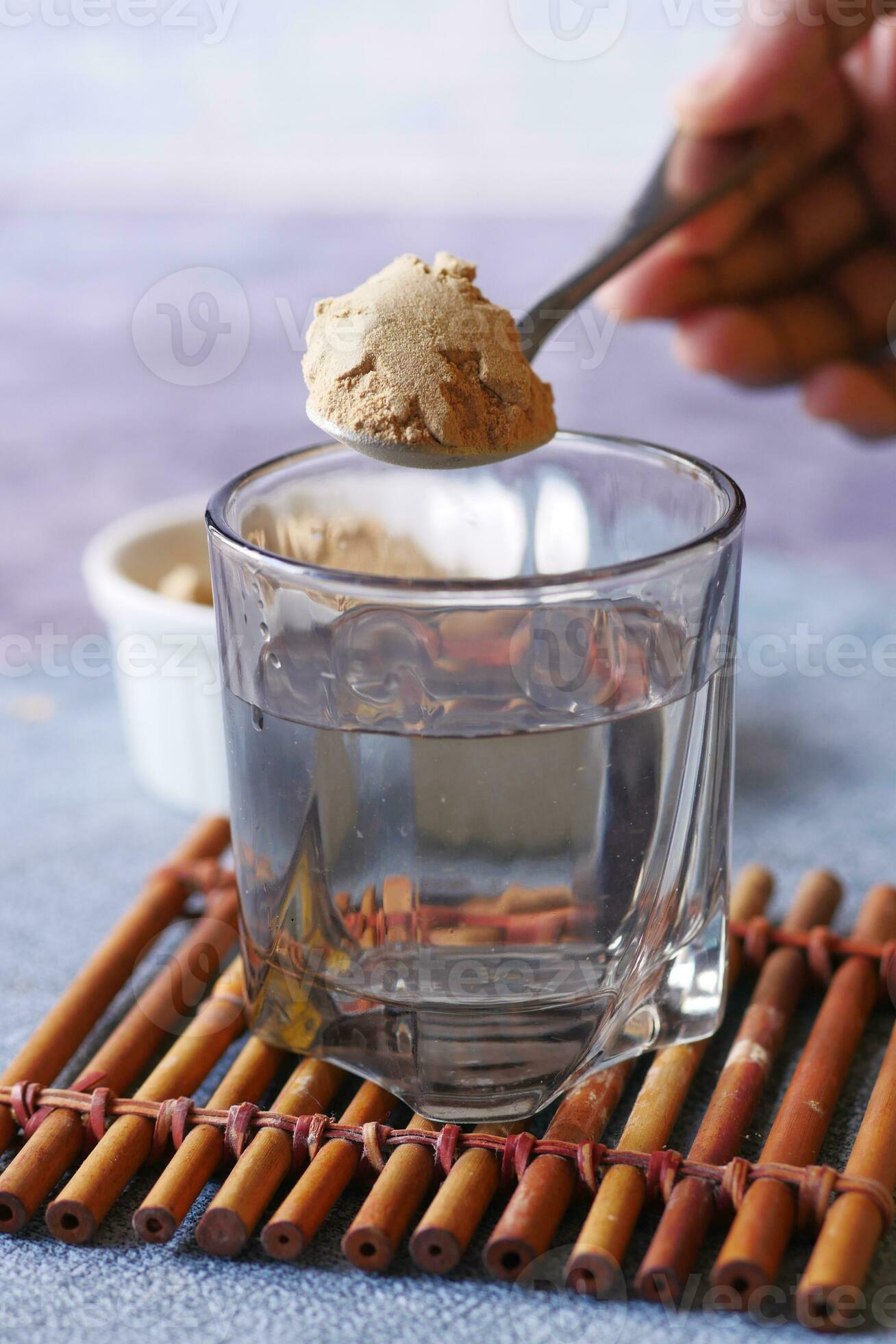 mixing brewers yeast flakes in a glass of water 24200539 Stock Photo at