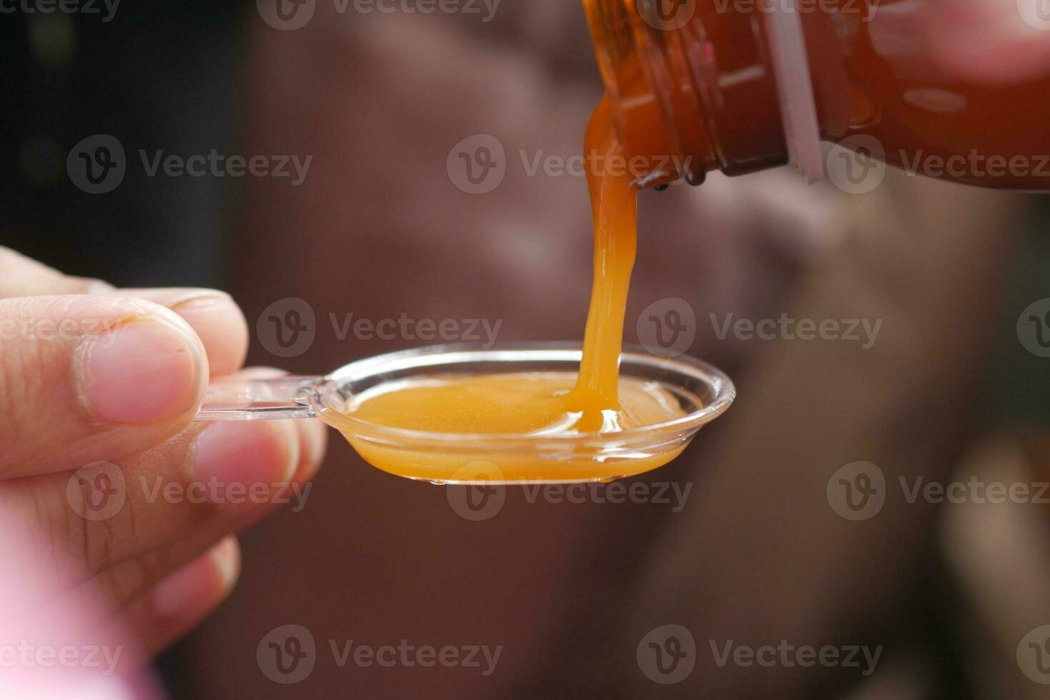 pour liquid medicine on top of spoon photo