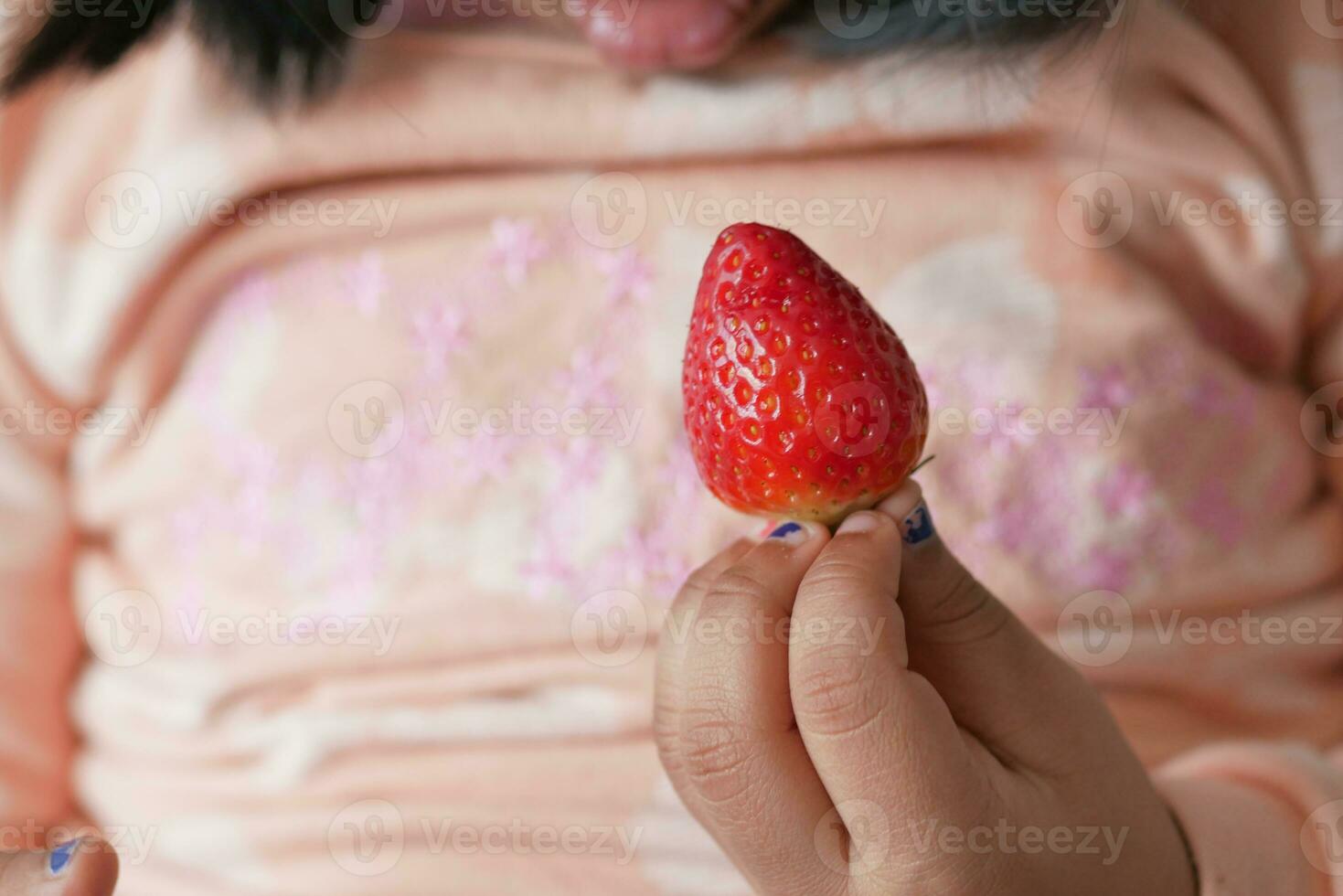 baby hand holding a Strawberry photo