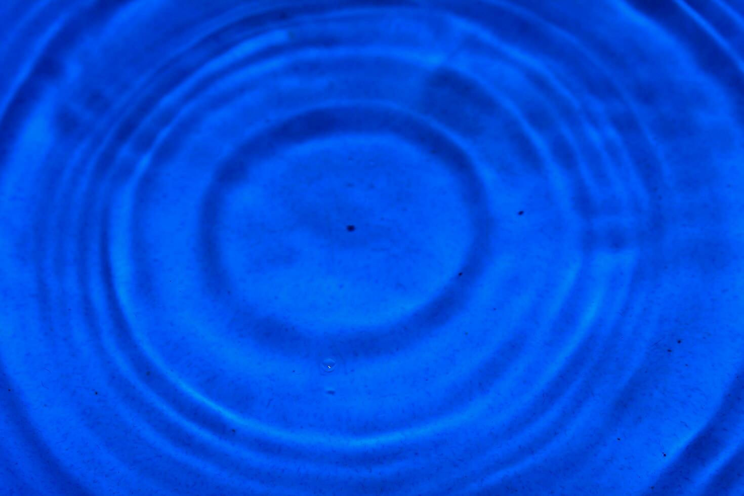 Water drops fall on the blue water surface photo