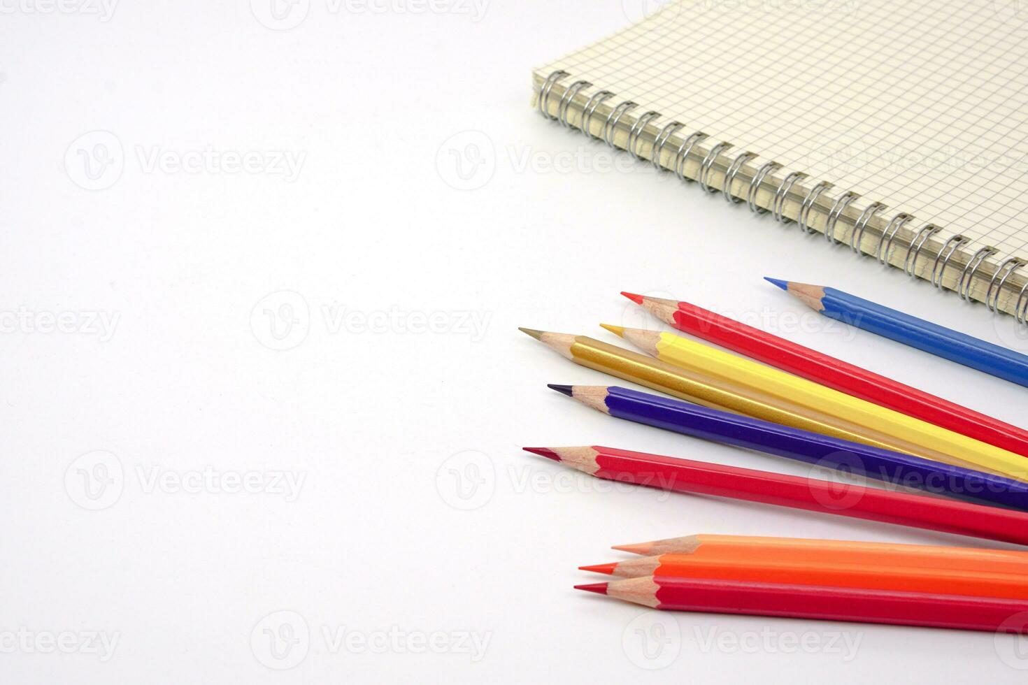 Focus of colored pencils or pastel lined up and blur graph book on white background. Learning, study and presentation concept. photo