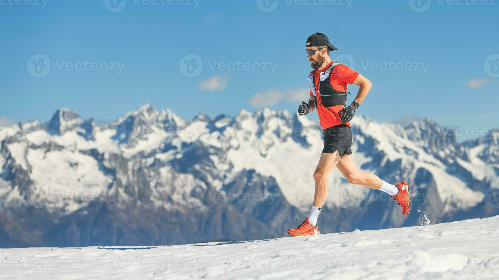 Trail running athlete runs in the snow photo