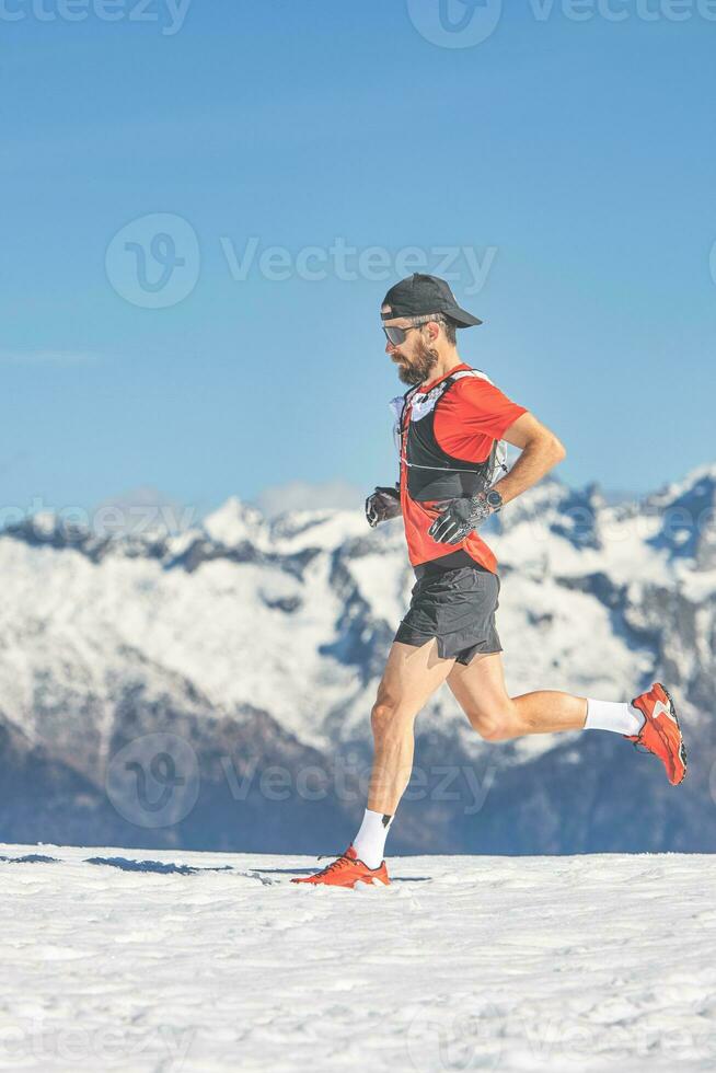 Trail running athlete runs in the snow photo