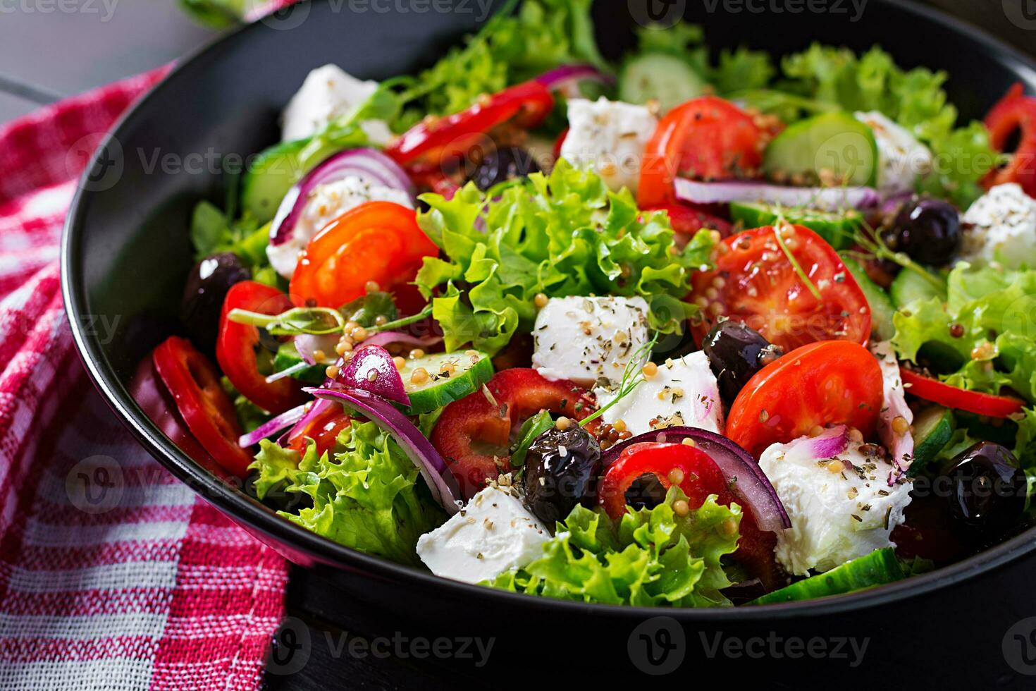 sano alimento. griego ensalada con pepino, tomate, dulce pimienta, lechuga, rojo cebolla, queso feta queso y Olivos. foto