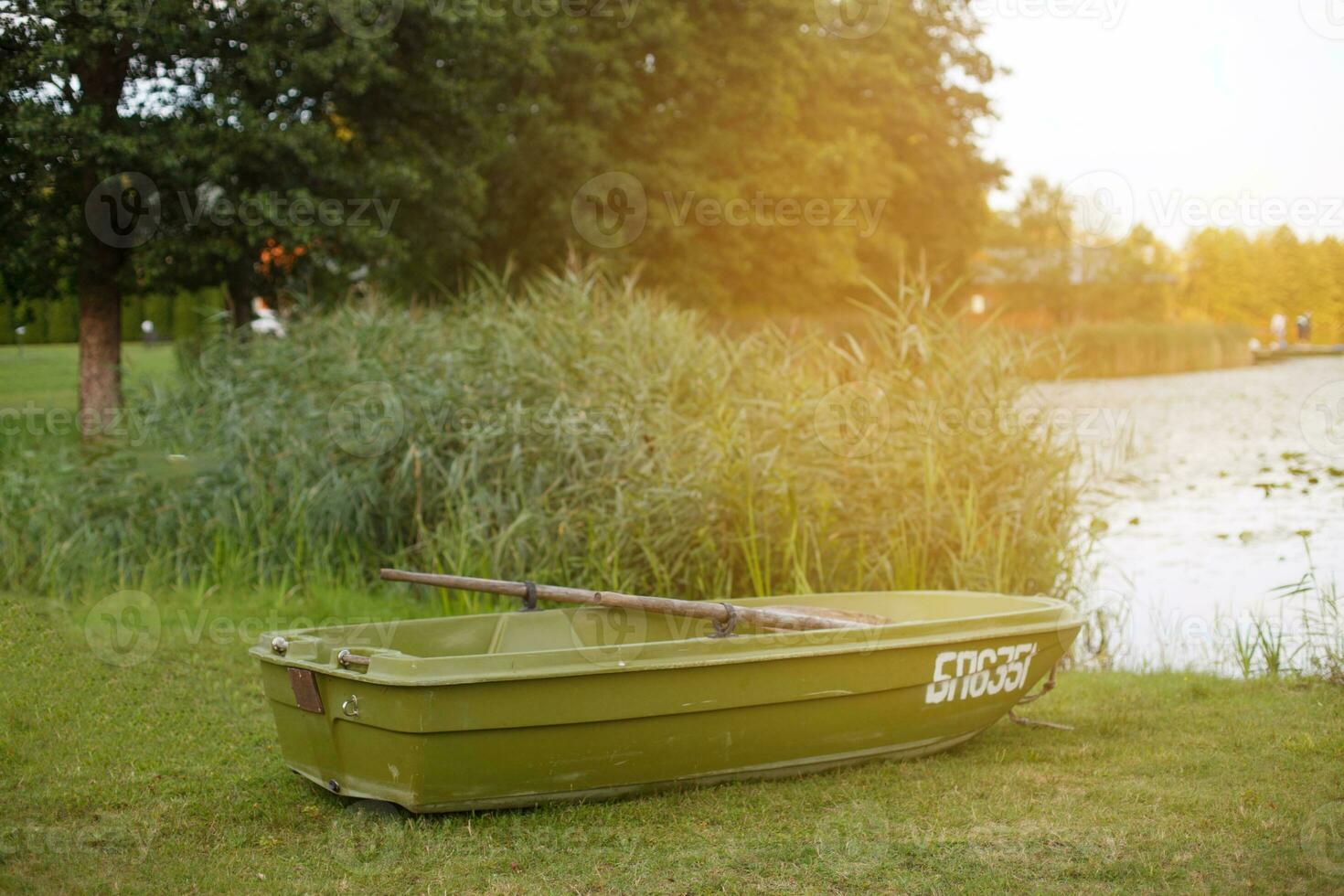 a boat on the grass of the shore of calm lake photo