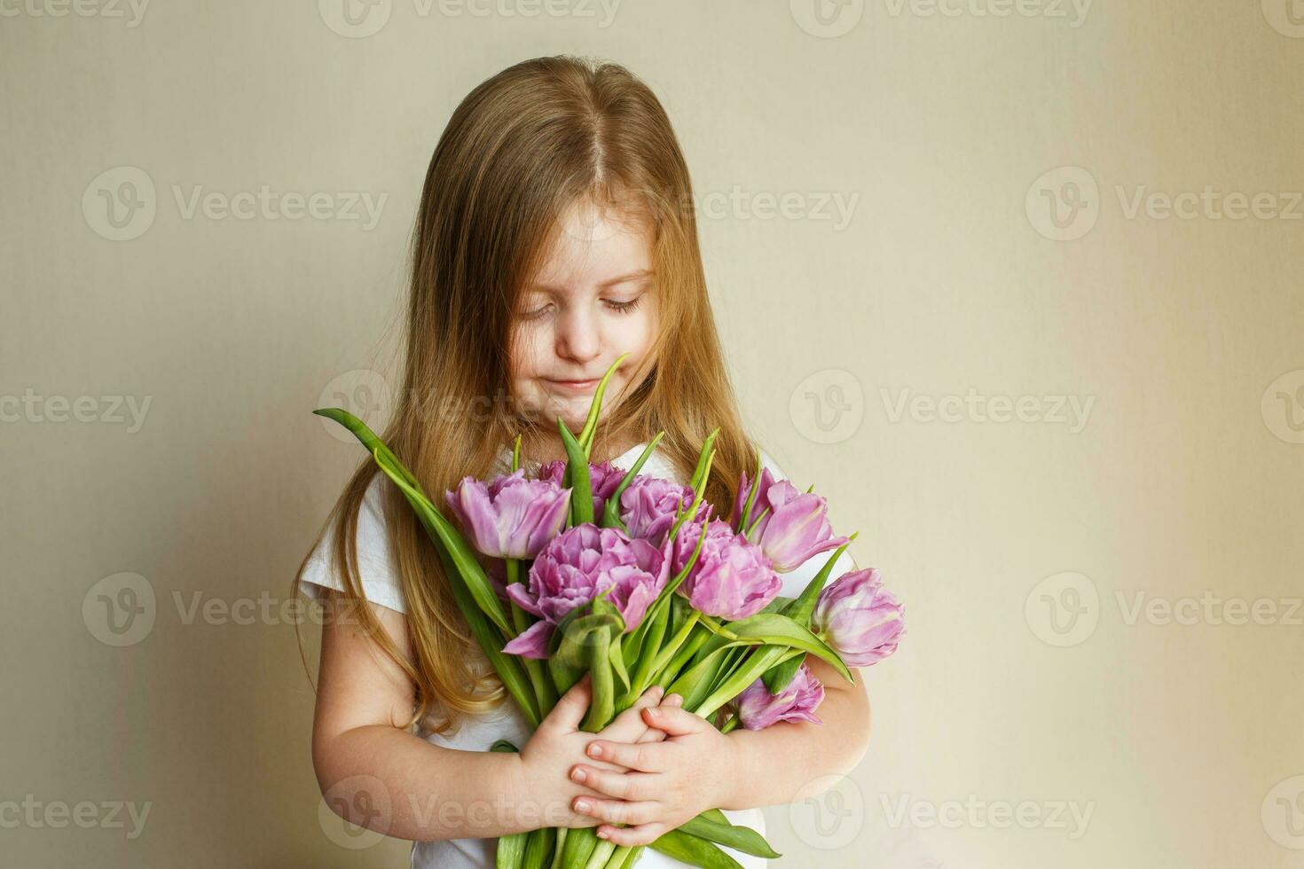 portrait of litlle girl with bouquet of flowers tulips in her hands photo