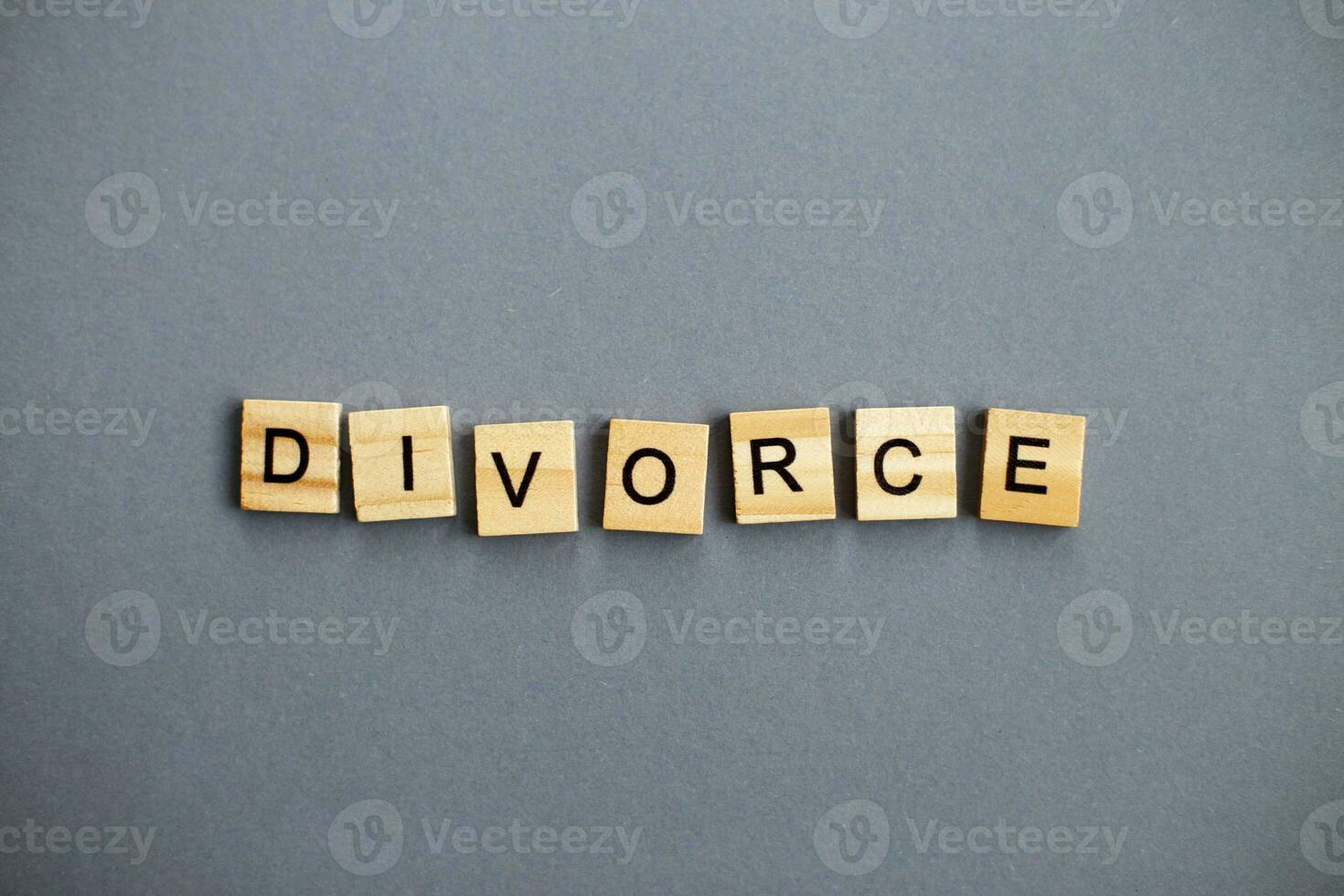 inscription divorce made by wooden blocks on gray background. broken family concept photo