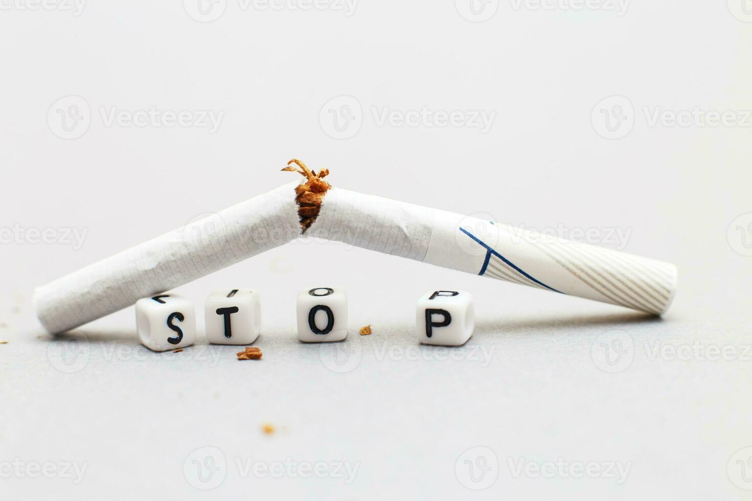 broken cigarette with the word stop on gray background close. stop smoking concept photo