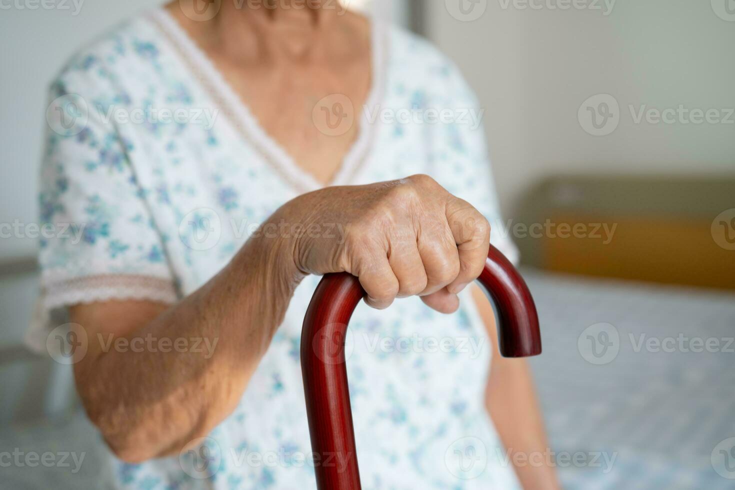 Asian elderly disability woman holding waling stick, wood cane, round handle, walking aid for help to walk. photo