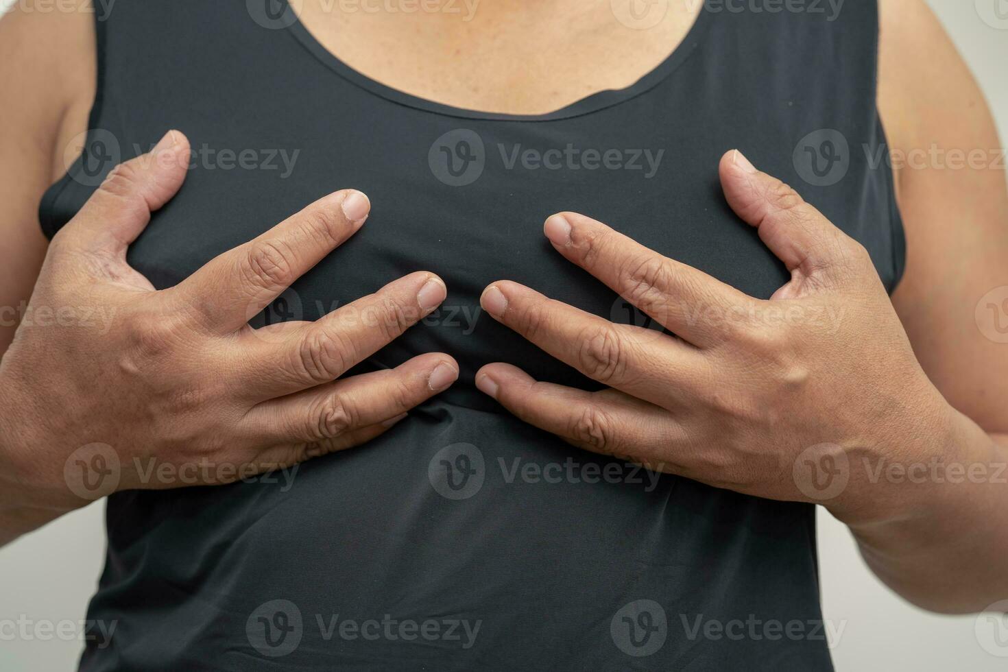 Asian woman patient checking and worry her breast, Breast Self Exam or BES, symbol of World Breast Cancer Day. photo