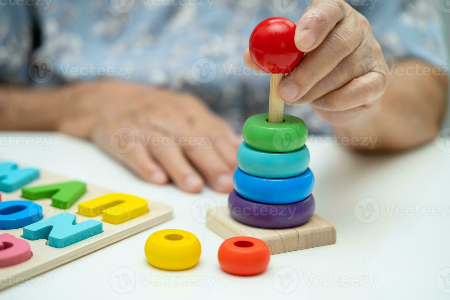 Alzheimer disease AD, Asian elderly woman patient suffering from dementia learn practical motor skills rehabilitation. photo