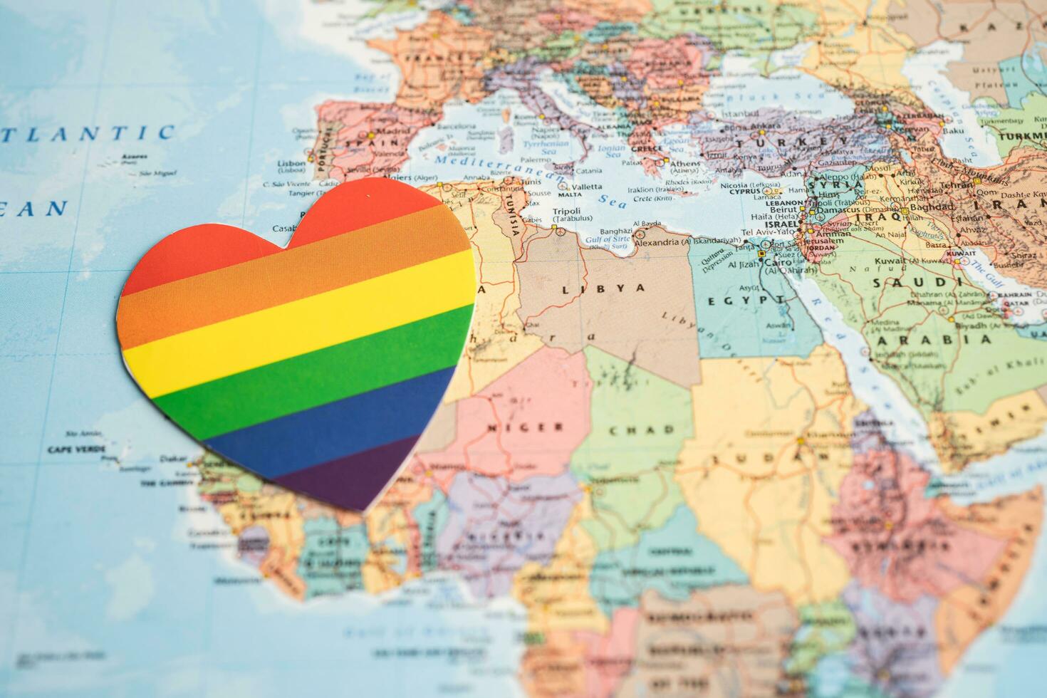 Bangkok, Thailand, June 1, 2022 Rainbow color heart on globe world map background, LGBT pride month celebrate annual in June, symbol of gay, lesbian, bisexual, transgender, human rights and peace. photo