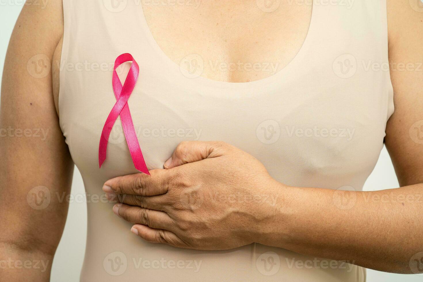 paciente mujer asiática revisando y preocupando su seno, autoexamen de seno o bes, símbolo del día mundial del cáncer de seno. foto