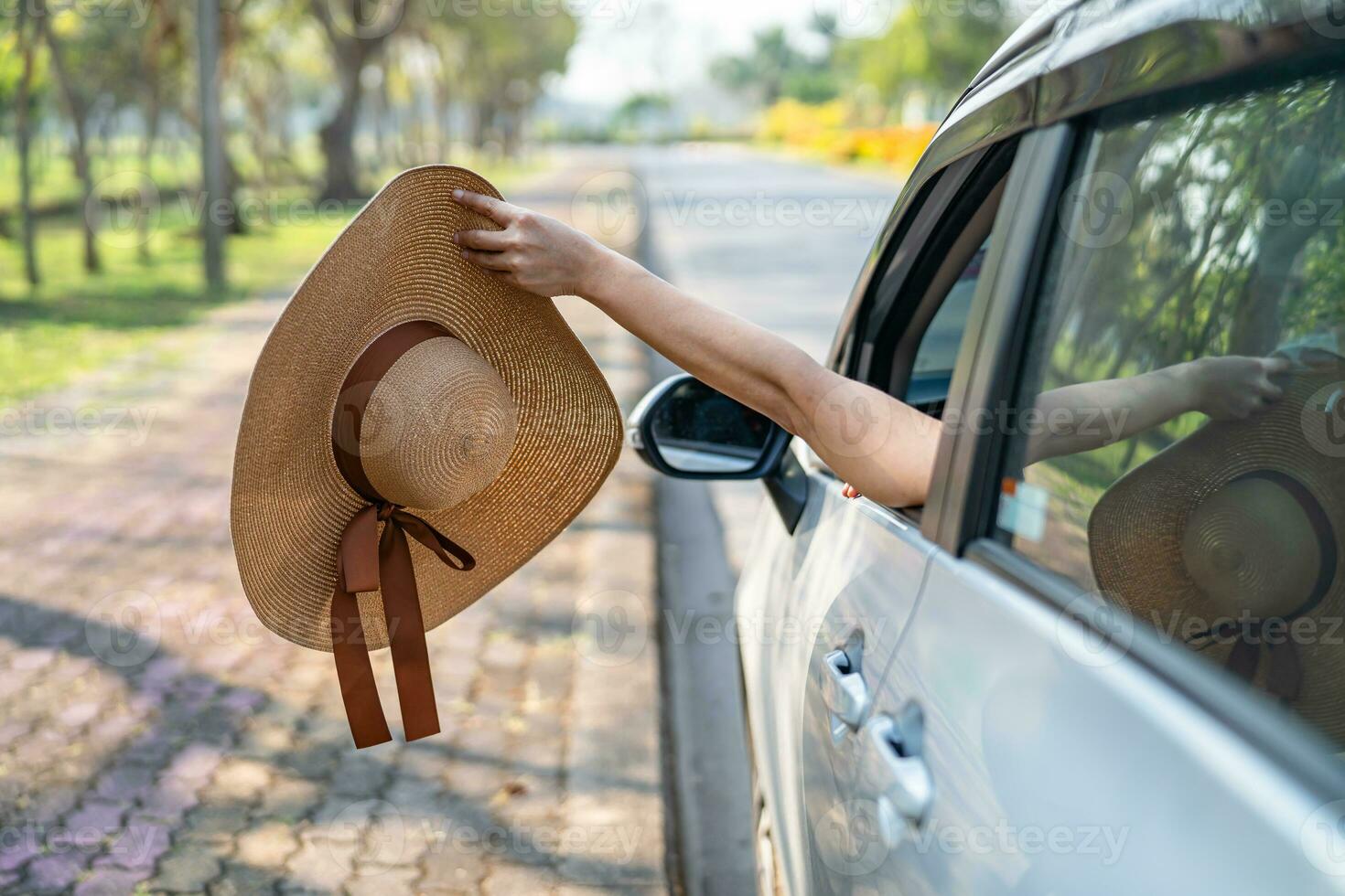 Happy enjoy and freedom in traveling trip with raised hand and holding hat outside of window car in summer vacation holiday. photo