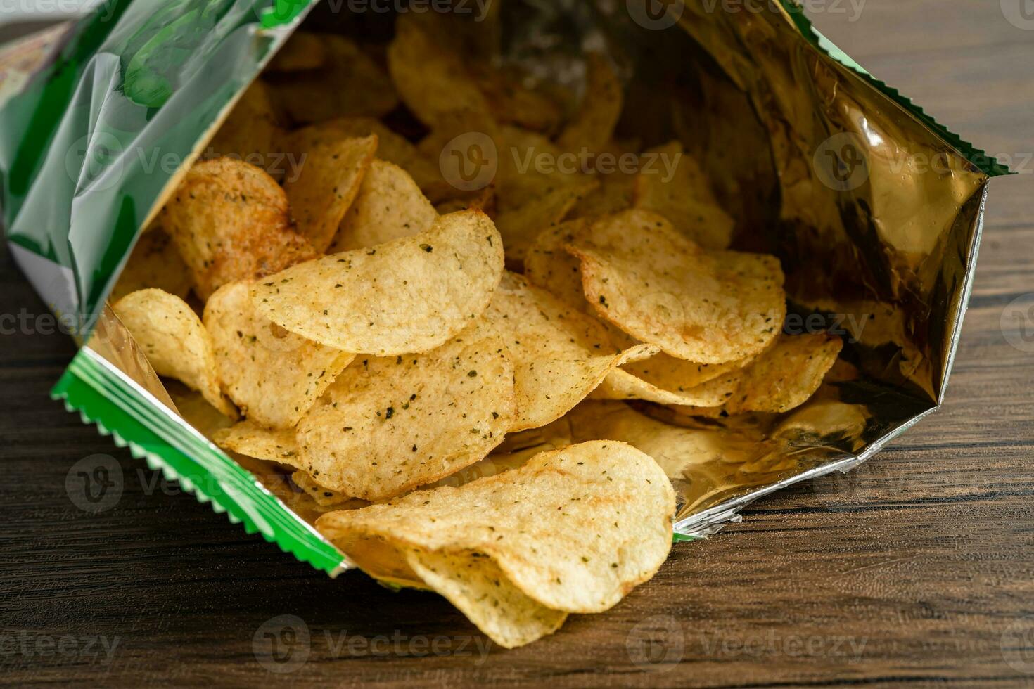 Potato chips, delicious spicy for crips, thin slice deep fried snack fast food in open bag. photo