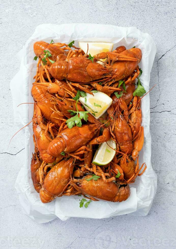 top view of cooked crawfish platter with lemons and spices photo