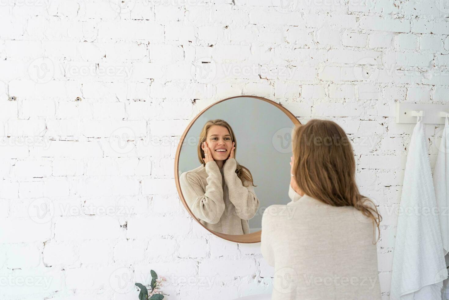 Woman looking at the mirror, making up in the morning photo