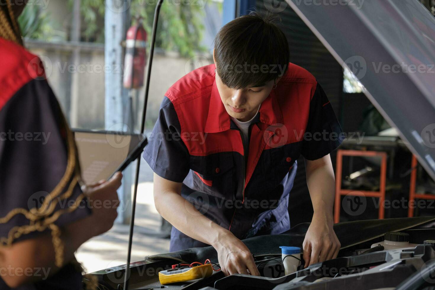 Two professional automotive mechanical partners check and repair an EV car battery and hybrid engine at a maintenance garage, expert electric vehicle service, and fixing occupations auto industry. photo