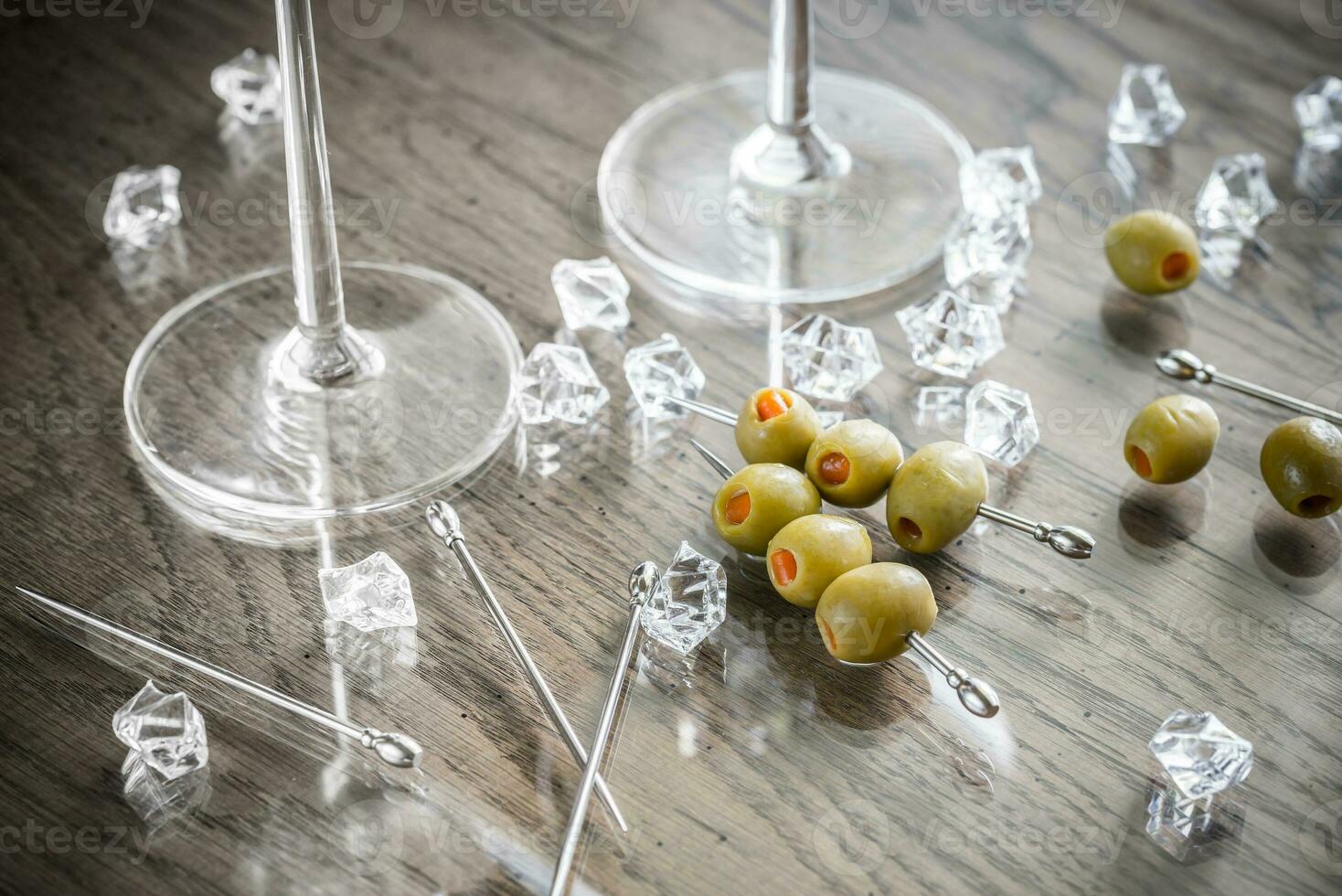 Two martini glasses with olives on martini picks photo