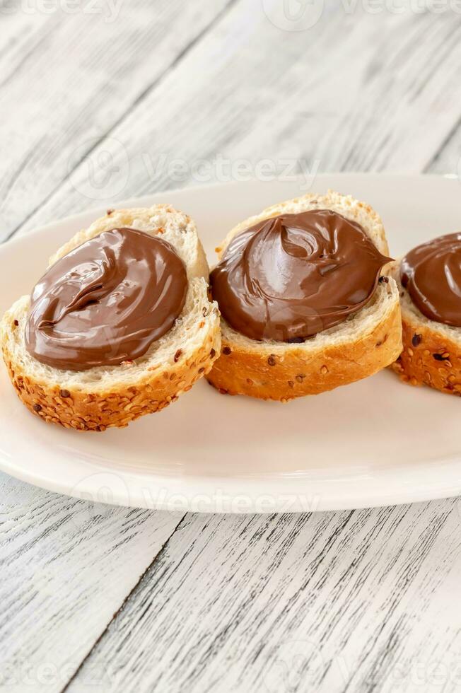 Slices of baguette with chocolate paste photo