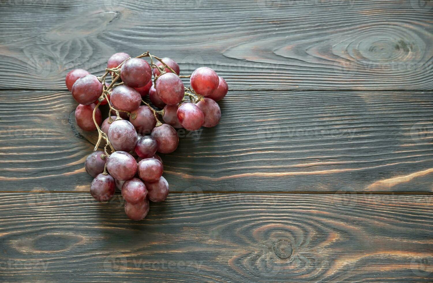manojo de rojo uva en el de madera antecedentes foto