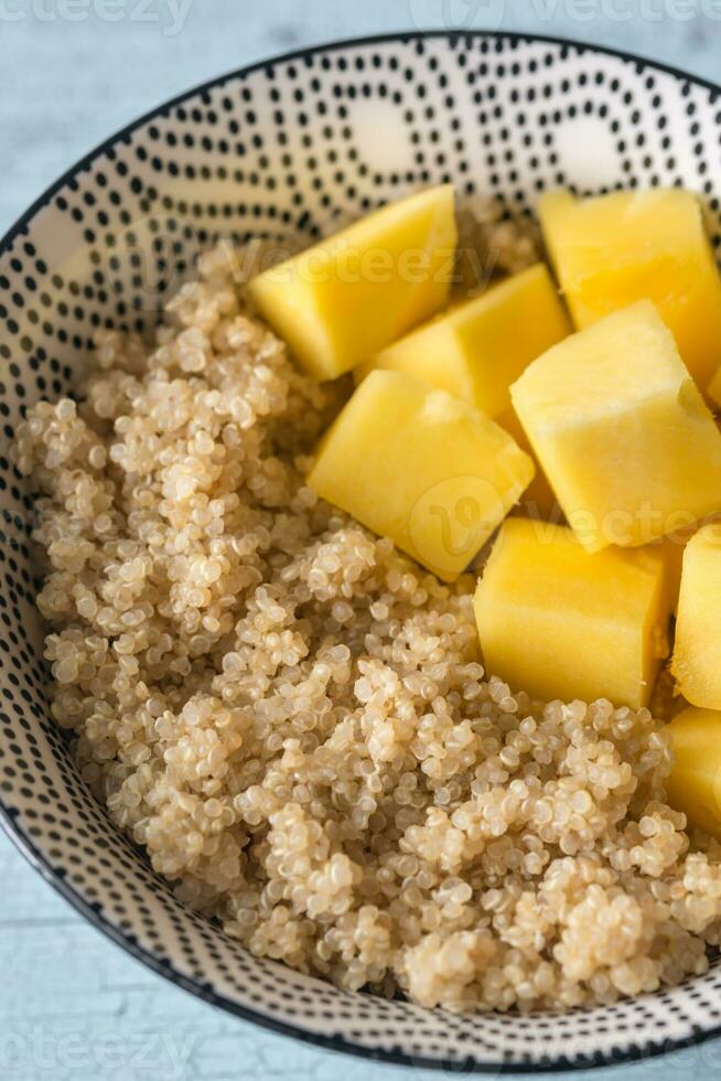 Portion of cooked quinoa with mango slices photo
