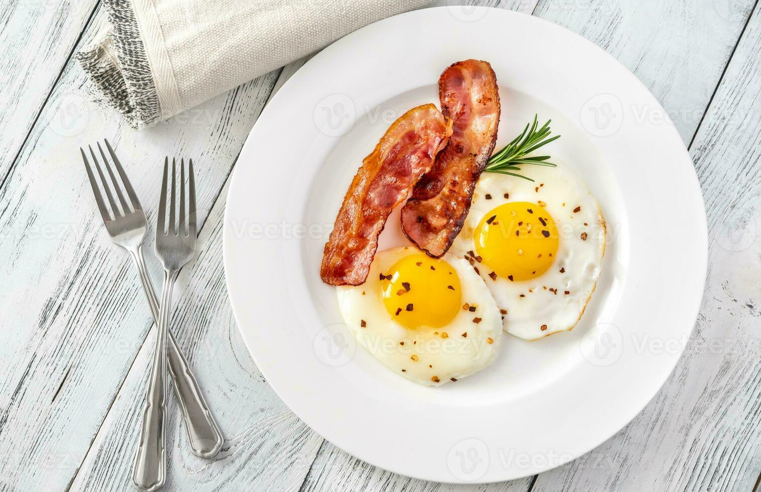 Fried eggs with bacon rashers photo