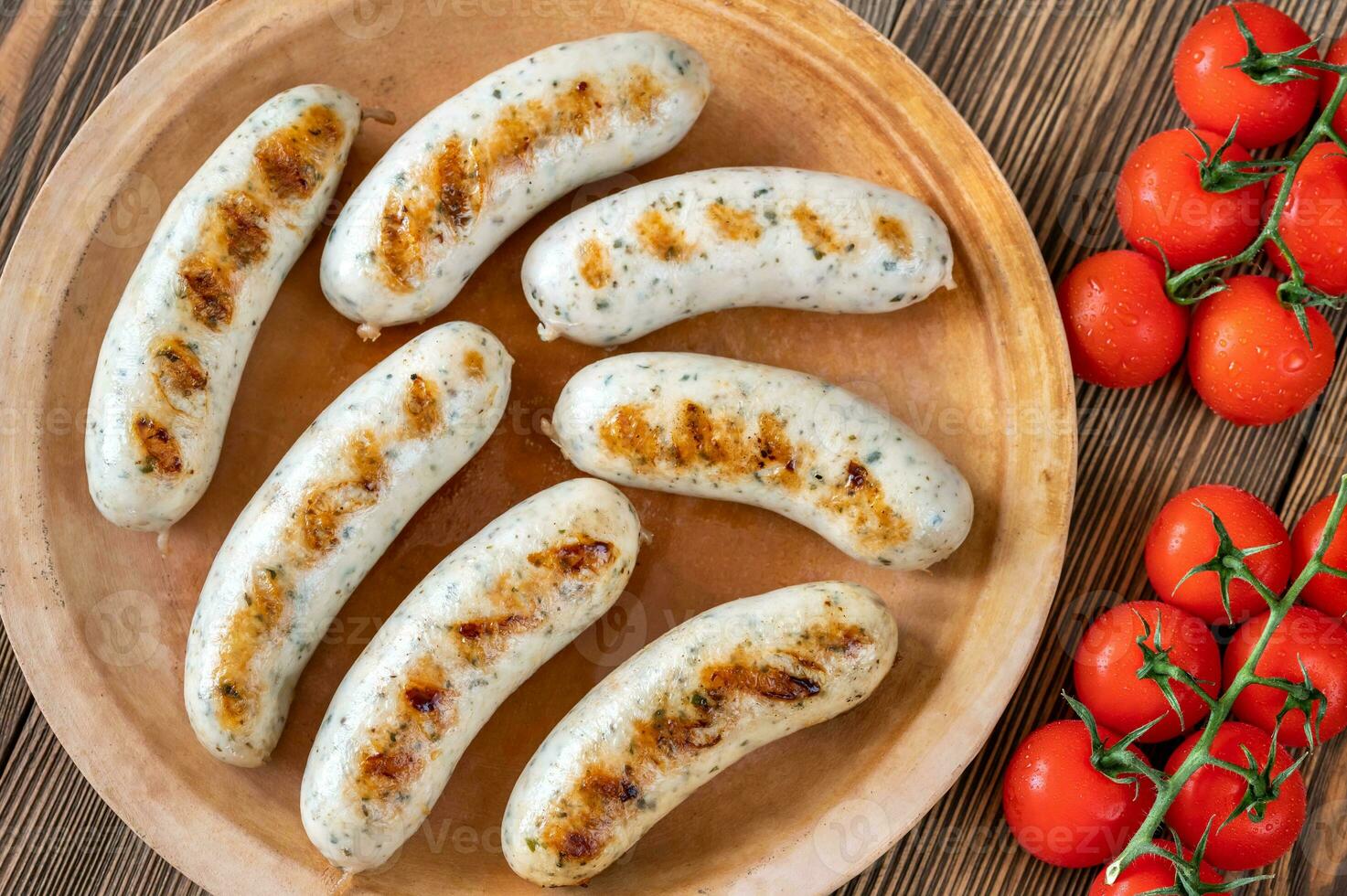 Grilled sausages on rustic plate photo