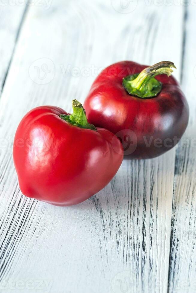 Fresh red bell peppers on the wooden table photo