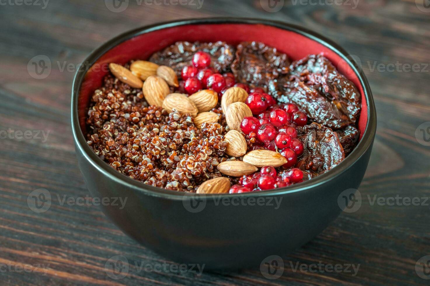 Bowl of red quinoa with nuts and sun-dried tomatoes photo