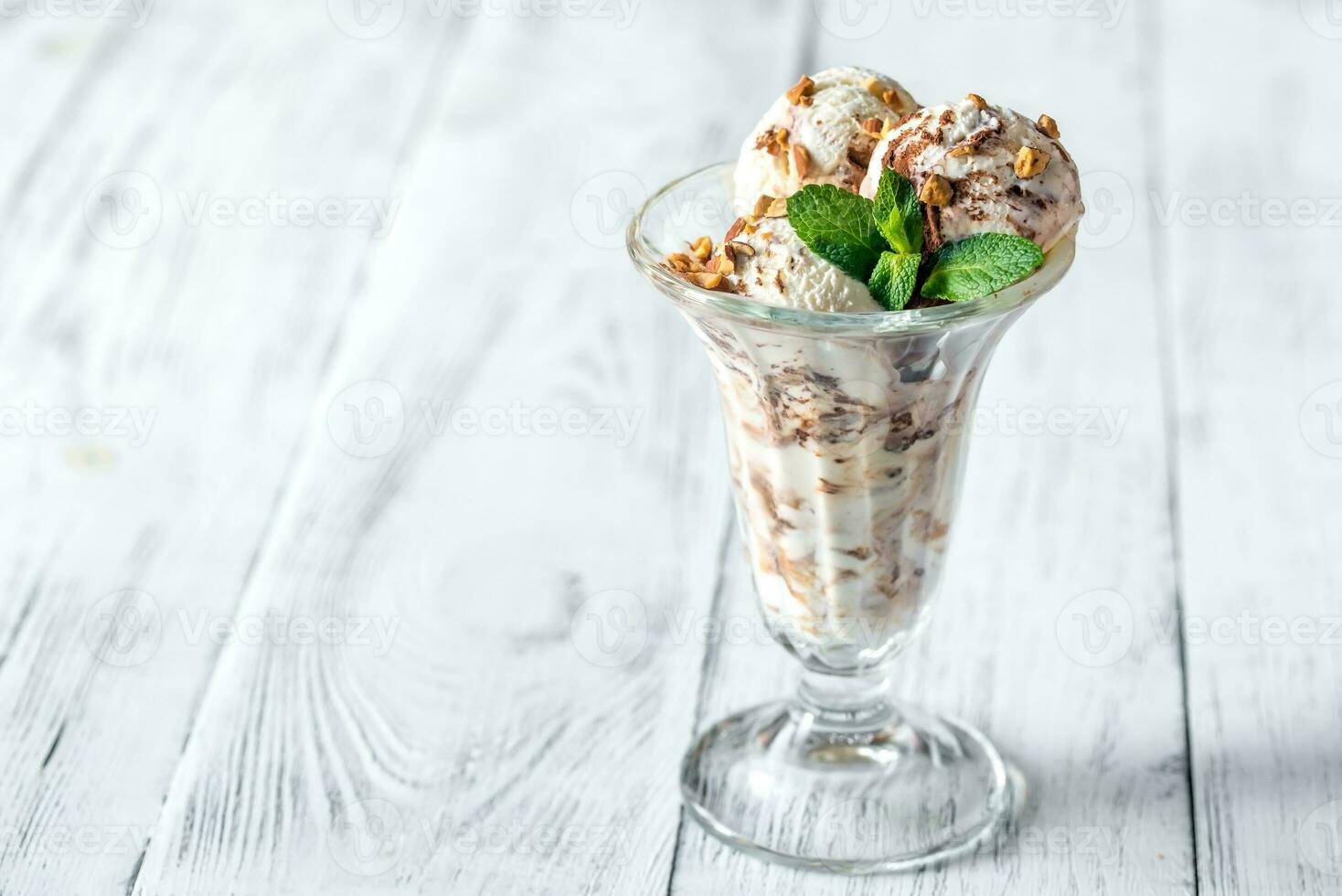 vainilla-chocolate hielo crema en un helado con frutas y nueces vaso foto