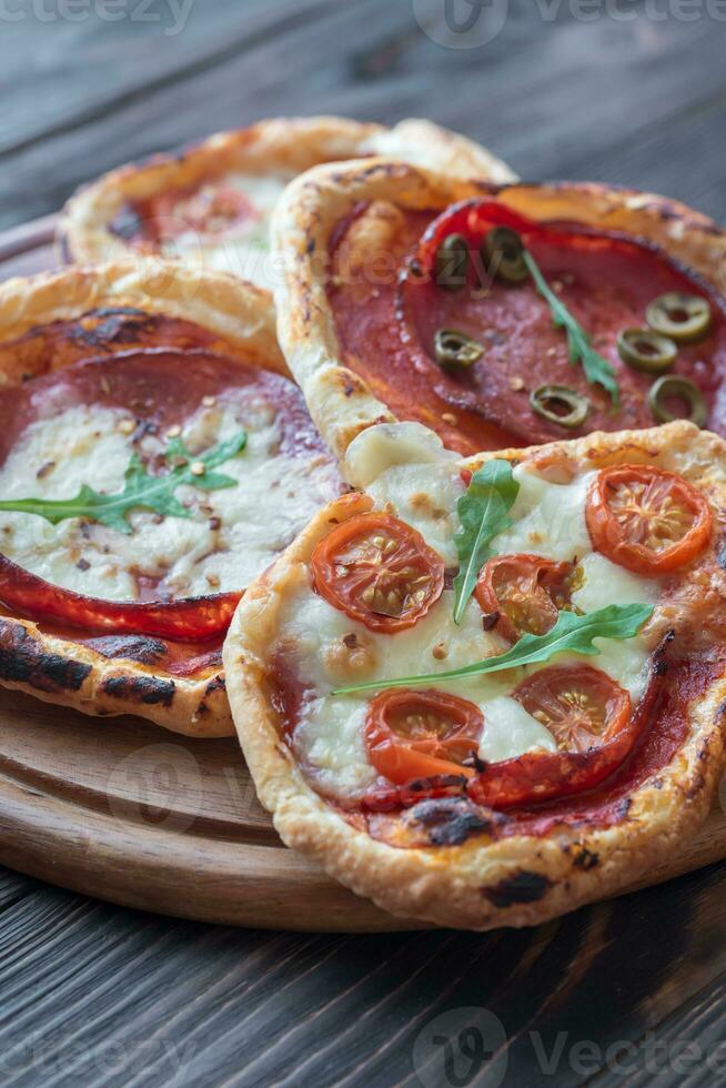 Mini pizzas on the wooden board photo