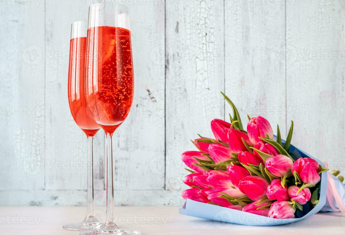 Glasses of champagne with bouquet of tulips photo