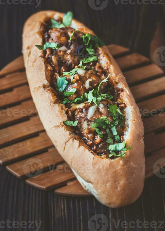 Hot dog bun stuffed with meatballs photo