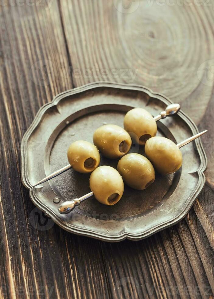 Olive skewer on the vintage plate photo