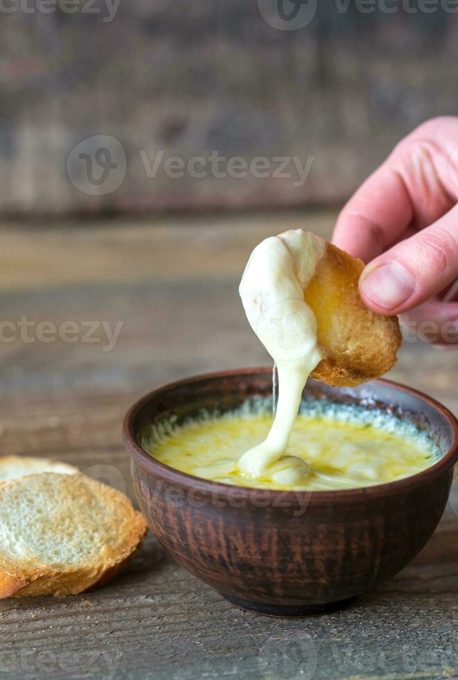 Bowl of cheese dip with toasts photo