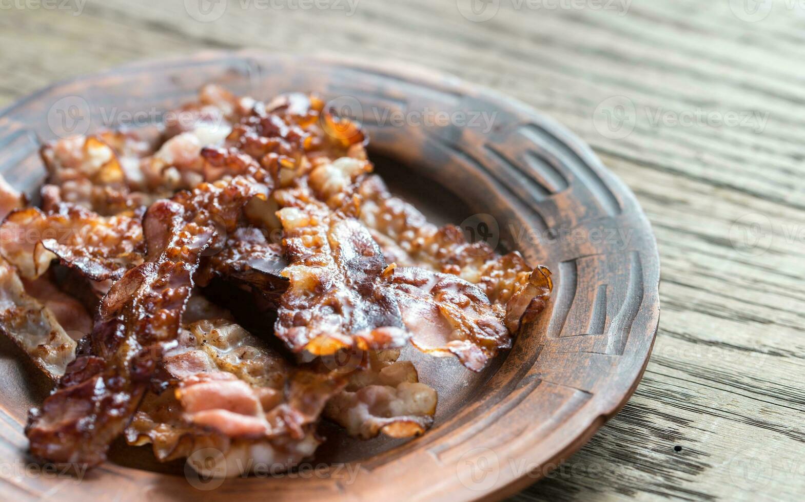 Fried bacon strips on the plate photo