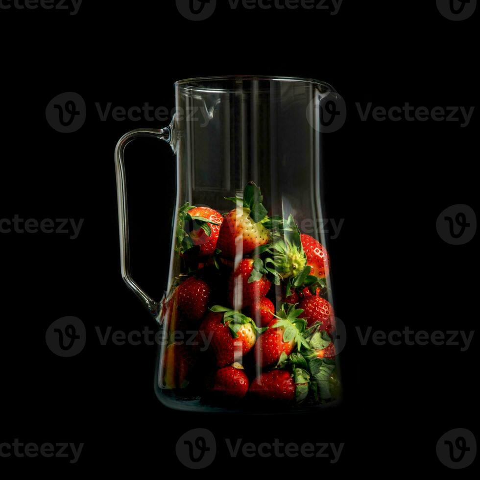 Strawberries in a glass jar with highlights on a black background. Modern strawberry design. Trendy harvest presentation. photo