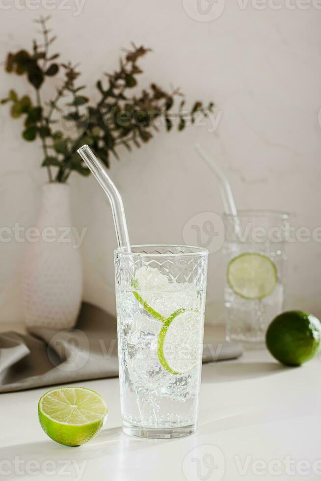 espumoso mineral agua con hielo y Lima en lentes para refresco en el verano vertical ver foto