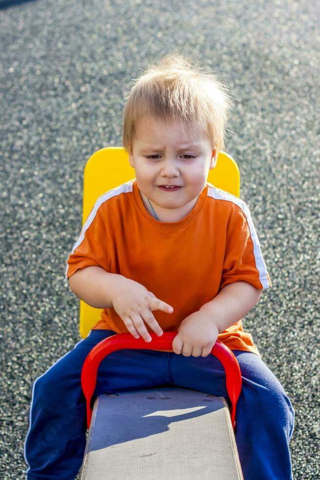 Portrait of a boy. A child is playing on the Playground. Riding on the swings. Happy child. photo