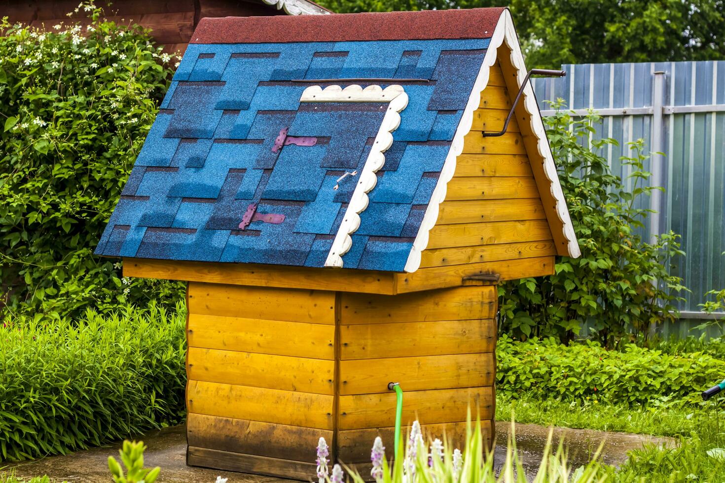 A beautiful village well with a blue roof. photo