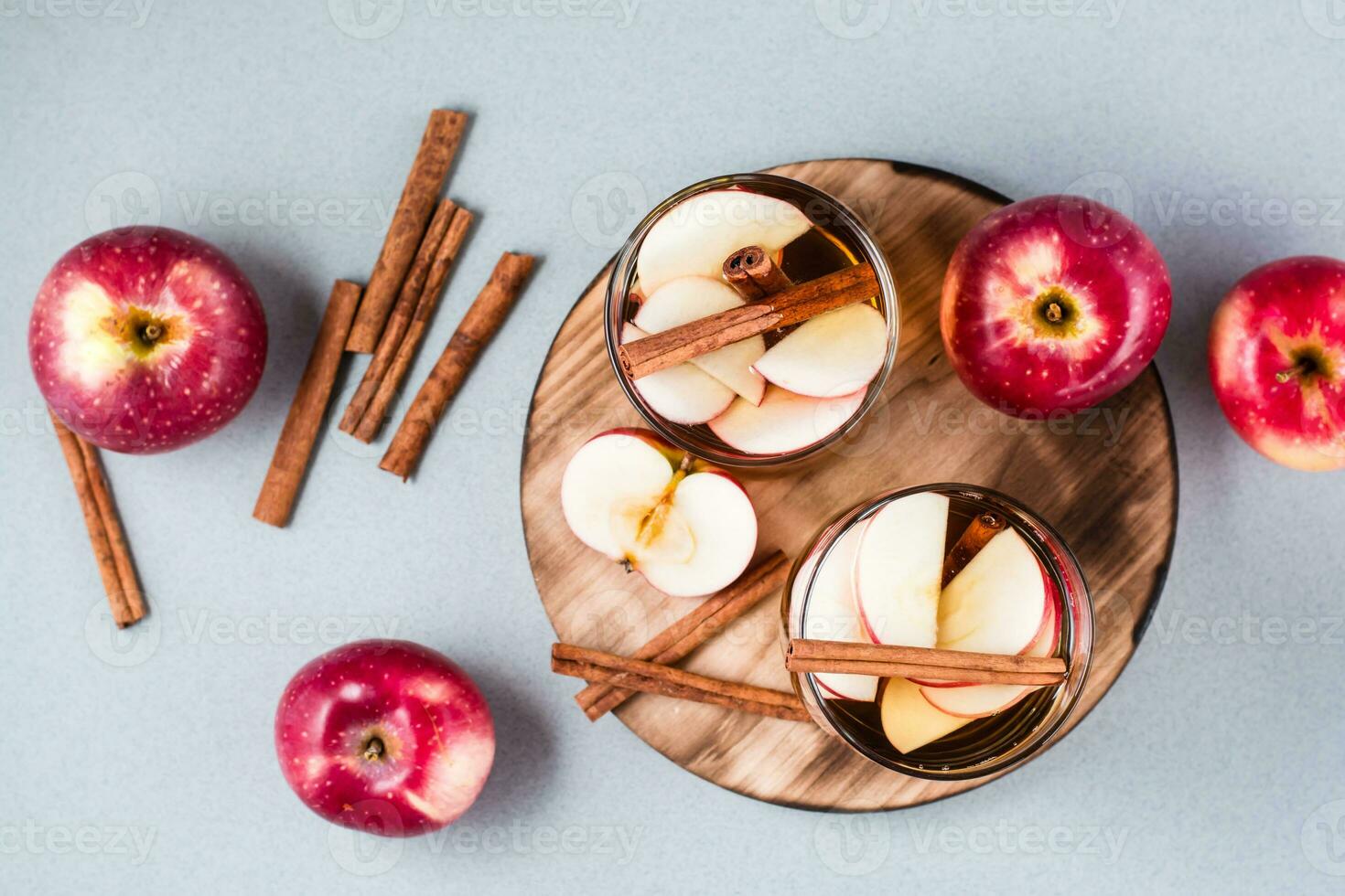 Homemade apple cider with cinnamon in glasses on a gray background. Warming winter drinks. Top view photo