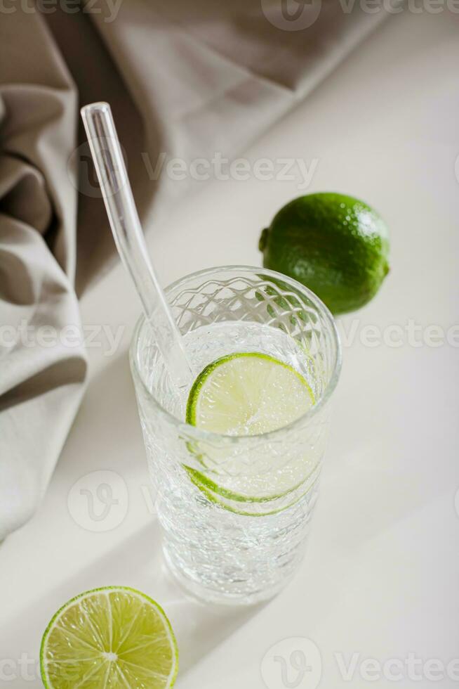 Hard seltzer with ice and lime in glasses on the table vertical view photo