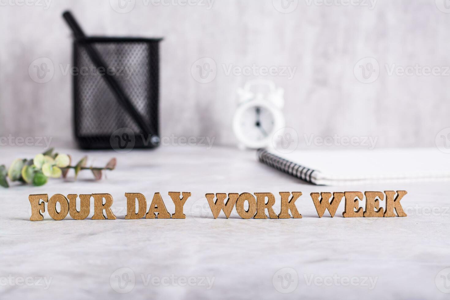 Four day work week word from wooden letters on desktop concept photo