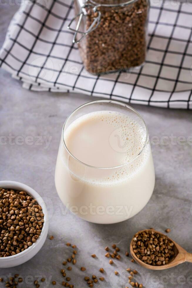 lactosa gratis dietético alforfón Leche en un vaso y semillas en un cuenco en el mesa vertical ver foto