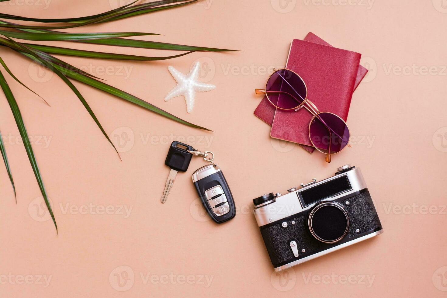 Bright travel flat lay with sunglasses, passports, vintage camera and car keys on a beige background. Car travel. Top view photo