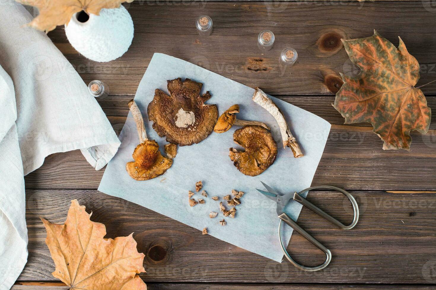 Dried chopped amanita ready to eat on parchment and scissors on a wooden table. Microdosing and Alternative Medicine. Top view photo