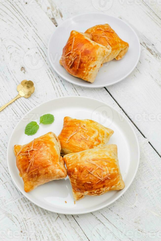 Banana Bolen Cake on a white plate on a wooden background. Bolen Pisang. photo