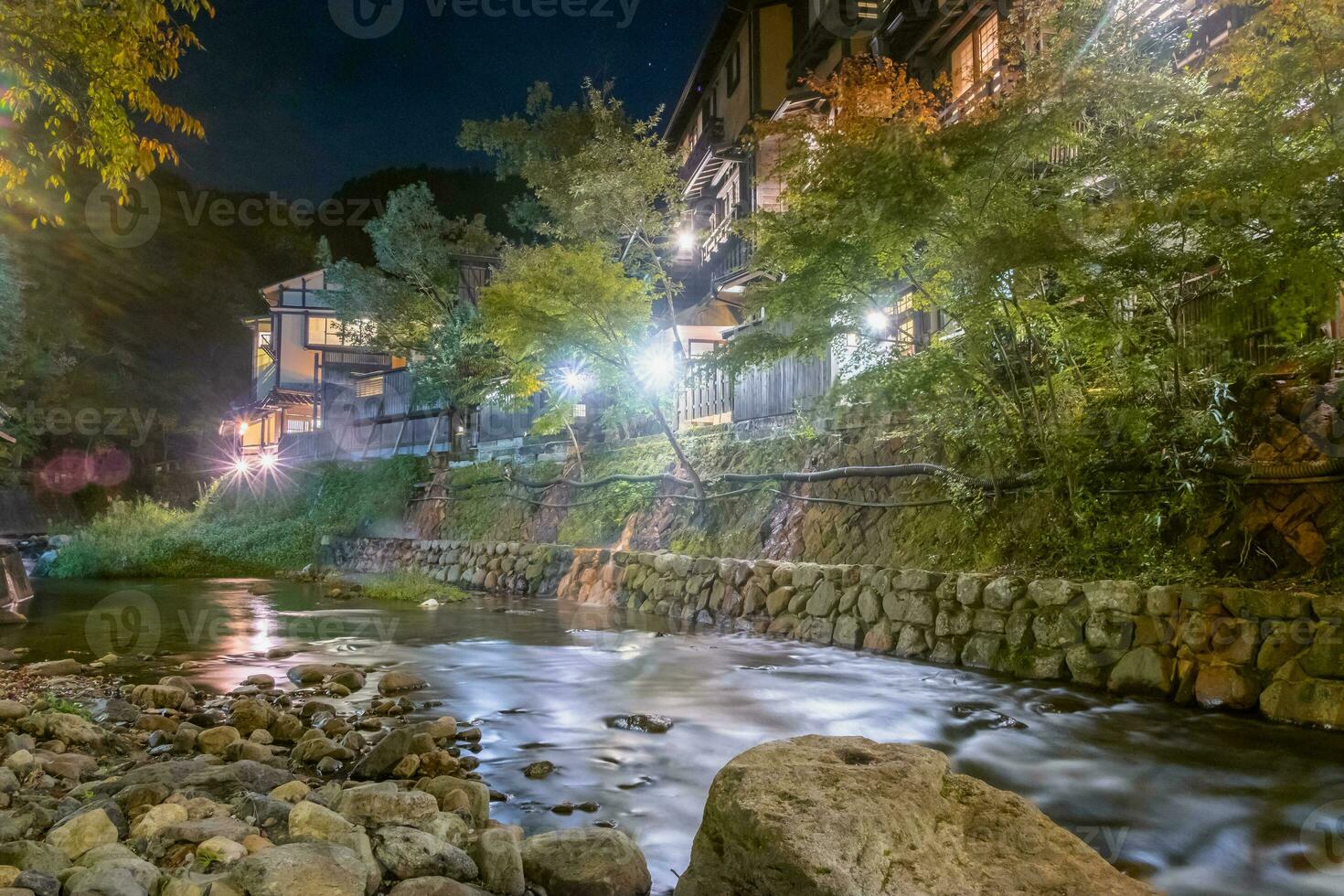 caliente primavera pueblos, kurokawa onsen, ryokan y puente a noche con Encendiendo llamarada, kurokawa, kumamoto, kyushu, Japón foto