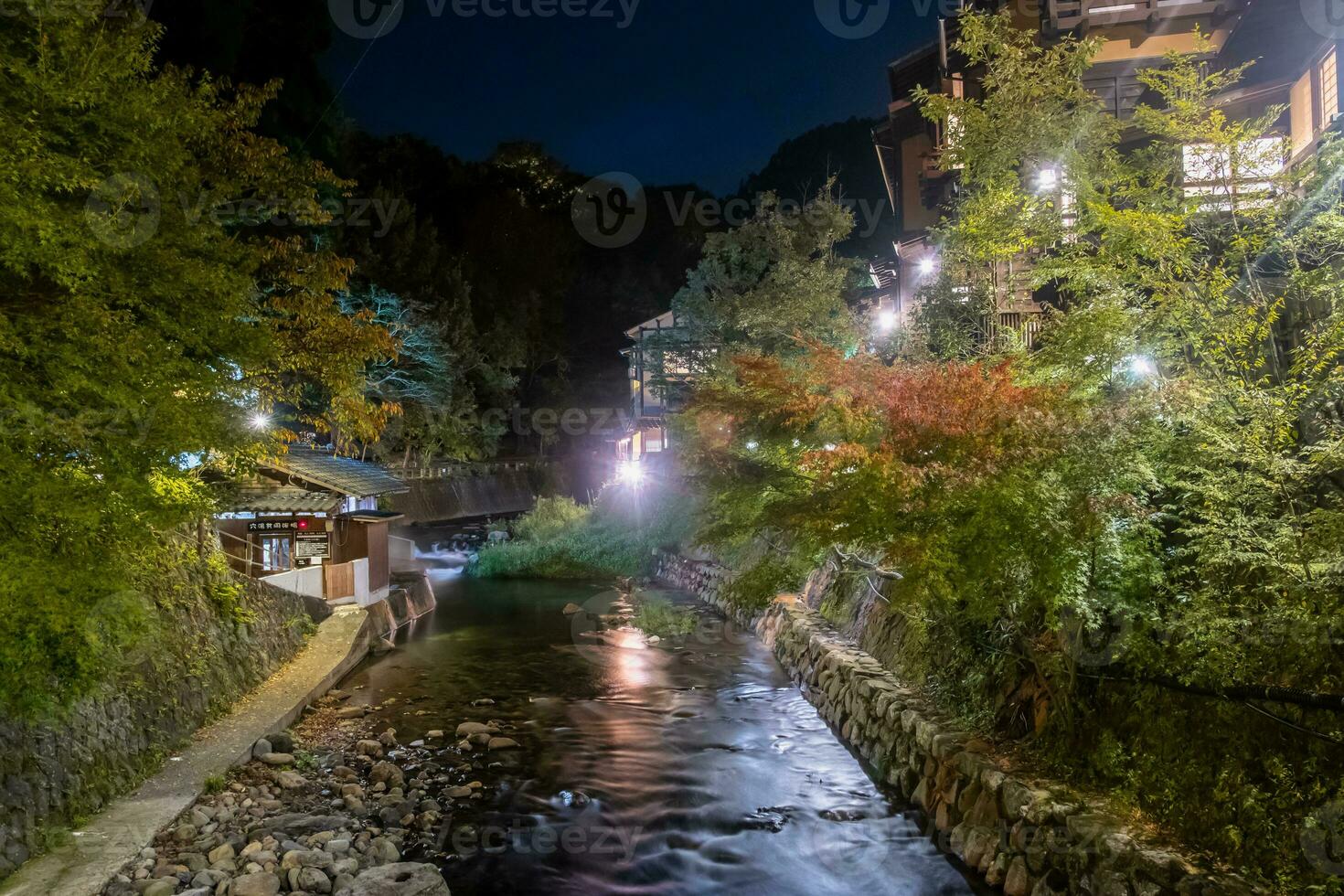 caliente primavera pueblos, kurokawa onsen, ryokan y puente a noche con Encendiendo llamarada, kurokawa, kumamoto, kyushu, Japón foto